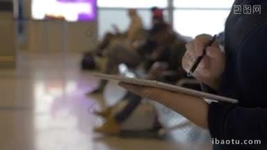 斯坦尼康拍摄的一个女人忙于工作在机场休息室，她用钢笔触摸
